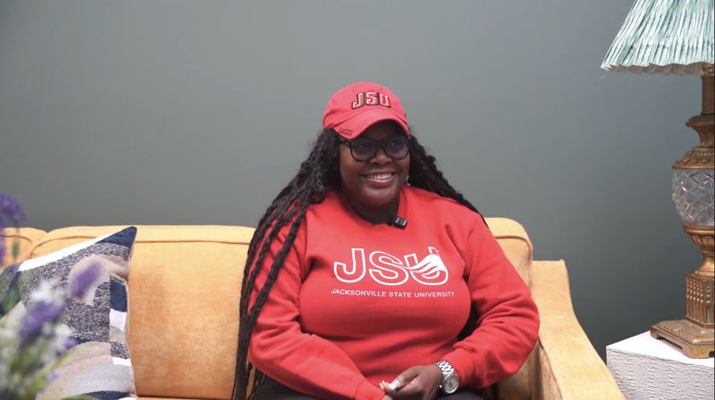Ashley, a future Langston Park homeowner, smiling on a couch