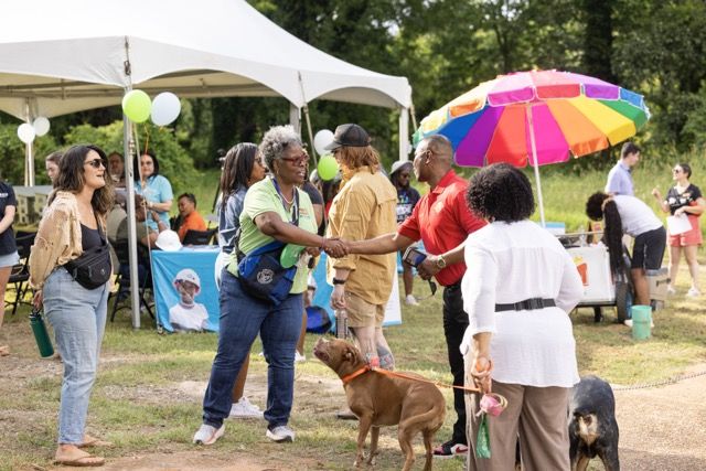 Tia McCoy, neighborhood engagement director for Atlanta Habitat, greets residents at the Sylvan Hills Kickback